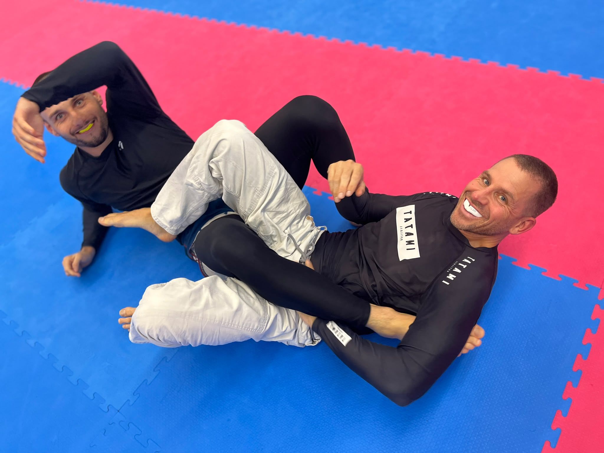 Zwei lachende Trainingspartner auf der Matte